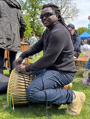 Foto Baye auf seiner Trommel kniend
